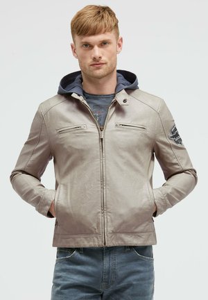 Hellgraue Lederjacke mit Reißverschluss vorne, zwei Brusttaschen und blauer Kapuzenfutter. Mit strukturierten Details und Schulterpatch.