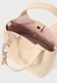 Τσάντα χειρός από μπεζ δέρμα σουέτ με ροζ εσωτερικό από δέρμα· διαθέτει κοντή λαβή και ασημένιες μεταλλικές λεπτομέρειες. Περιλαμβάνει τσέπη με φερμουάρ.