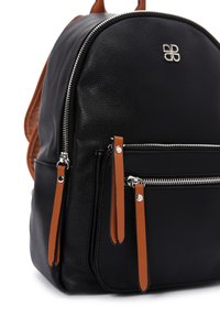 Sac à dos en cuir noir texturé avec des accents en cuir marron, fermetures éclair en métal argenté et doubles poches frontales avec des tirettes de fermeture éclair contrastantes.