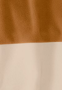 Καφέ και μπεζ ύφασμα με μαλακό, υφασμάτινο καφέ ανώτερο τμήμα και λείο μπεζ κατώτερο τμήμα, εμφανίζοντας μια απαλή πτυχή.