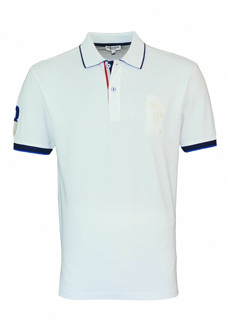 Polo blanc à manches courtes avec bordure bleu marine sur le col et les manches, patte de boutonnage avec détail rouge, et logo brodé discret sur la poitrine.