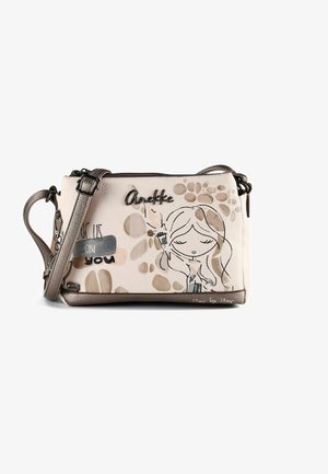 Beige Umhängetasche mit braunem Riemen, die eine Illustration eines Mädchens im Cartoonstil, abstrakte Flecken und den Text "Anekke" und "Walk on you" zeigt.