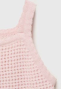 Svetlo roza pleteni top z teksturirano vafelno strukturo in rebrastim obrobjem. Ima široke naramnice in gladek zaključek.