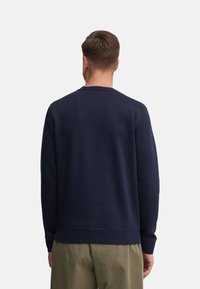 Felpa blu navy realizzata in tessuto morbido, con collo a giro e polsini a coste. Il design è semplice, senza motivi o accenti aggiuntivi.