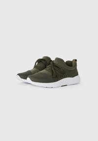 Baskets de sport vert olive avec un dessus en mesh et une semelle blanche. Dotées d'un bout arrondi et de lacets intégrés pour un ajustement parfait. Design texturé.