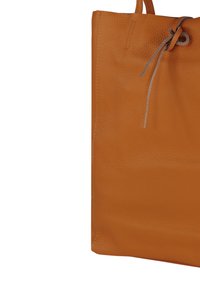 Orangefarbene Totetasche aus Leder mit strukturierter Oberfläche, ausgestattet mit einer Kordelzugverschluss und einfachen, klaren Linien. Minimalistisches Design ohne zusätzliche Akzente.