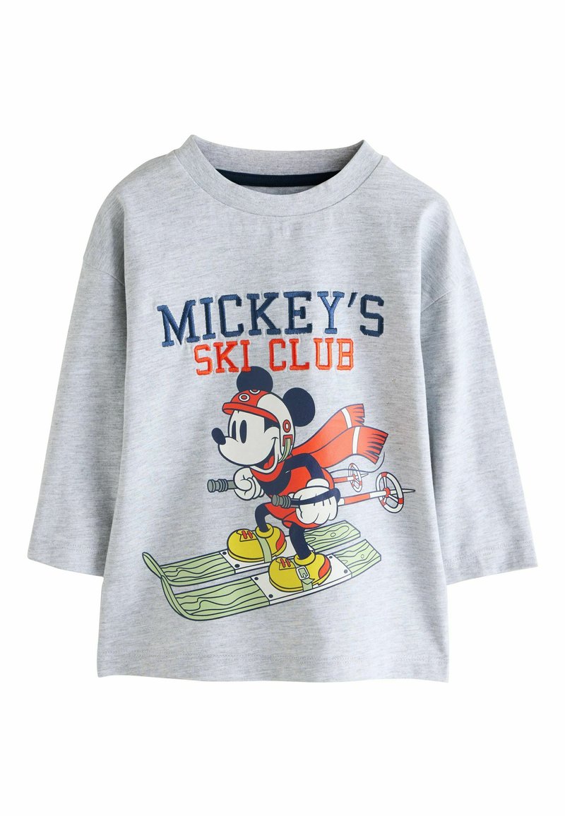 Szürke, hosszú ujjú póló, amelyen egy síelő karikatúra látható, kék és narancssárga felirattal: "MICKEY’S SKI CLUB" és grafikai részletekkel.