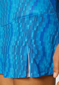 Μπλε αθλητικά σορτς με υφή σε διάφορες αποχρώσεις του μπλε και λευκή εσωτερική επένδυση. Διαθέτει πλαϊνές σχισμές και αντίθεση ραφής.