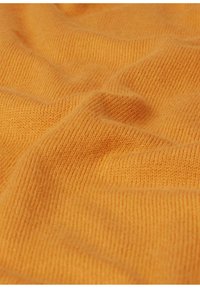 Gelbes gestricktes Gewebe mit einer glatten Textur und feinen Rippenmustern. Das Material erscheint weich und flexibel und bildet sanfte Falten.