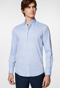 Jasnoniebieska koszula zapinana na guziki z małym geometrycznym wzorem, długimi rękawami, klasycznym kołnierzykiem i gładką strukturą materiału.