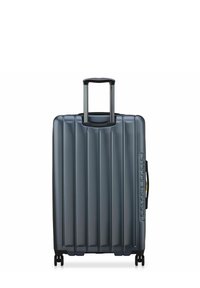 Valise rigide bleue avec rainures verticales, poignée rétractable, deux roues et poignée de transport latérale. Logo notable sur le côté.