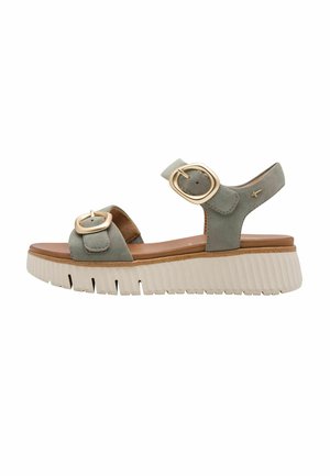 Sandalo verde in camoscio con due fibbie circolari dorate, soletta marrone e suola bianca spessa con trama rigata.