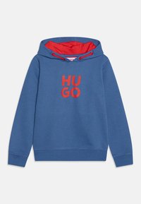 Sudadera con capucha azul y interior rojo, que presenta un gran logotipo rojo "HUGO" en la parte frontal. Material de algodón con puños y dobladillo de canalé.