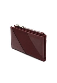 Portafoglio in pelle bordeaux con chiusura a zip, caratterizzato da un design geometrico con pannelli diagonali e una texture liscia. Forma compatta e slanciata.