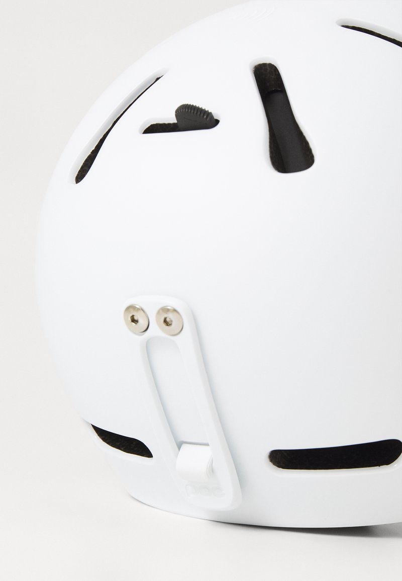 Weißer Helm mit Belüftungsschlitzen, einstellbarem Drehregler und hinterer Halterung. Glatte Oberfläche mit sichtbarem Zubehör und einem Logo in der Nähe der Basis.