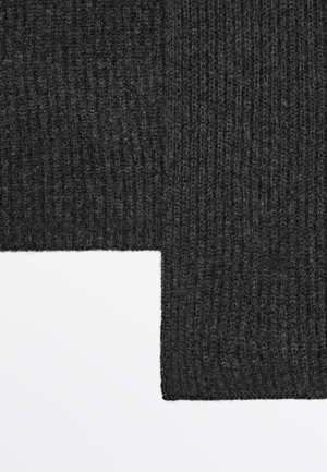 Gestrickter dunkelgrauer Stoff mit einer gerippten Textur, der eine markante Kante zeigt, an der der Stoff auf einen weißen Hintergrund trifft, was seine Dicke betont.
