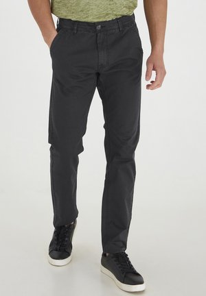 Black, slim-fit pants made of cotton blend fabric, featuring a front button closure, belt loops, and side pockets with a smooth texture.