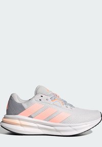 Zapatillas deportivas grises con acentos en rosa, parte superior de malla, diseño ligero, suela acolchada, con tres rayas diagonales en el lateral.