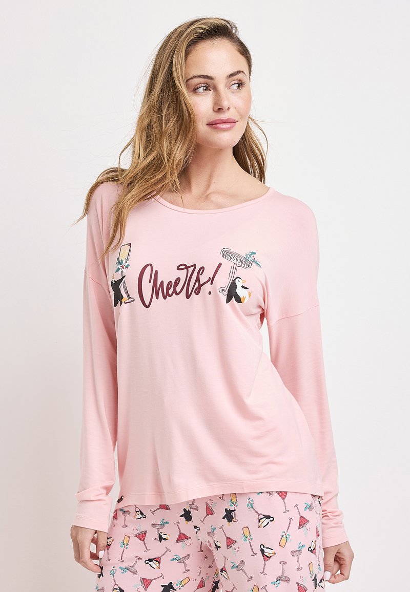 Ljusrosa långärmad topp med texten "Cheers!" och illustrerade pingviner och drycker. Matchas med rosa mönstrade pyjamasbyxor.