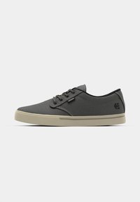 Scarpe casual da uomo in canvas grigio scuro con suola in gomma beige chiaro. Presentano lacci tondi e un accento di logo nero sul lato.