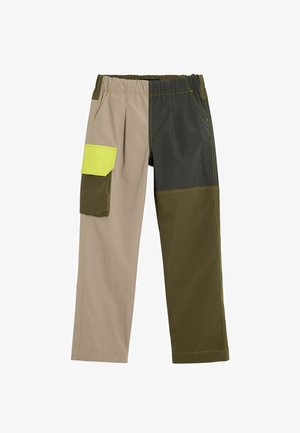 Pantalones multicolores que combinan secciones en beige claro, verde oscuro y verde oliva. Incluyen un bolsillo amarillo de color brillante. Cintura elástica.