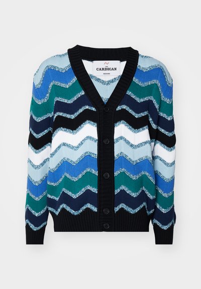 Texturerad cardigan med en chevronmönster i nyanser av blått, grönt och svart, med en svart ribbad halsringning och fem knappar.