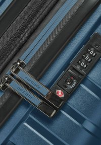 Valigia rigida blu con doppie cerniere e un lucchetto a combinazione TSA nero.