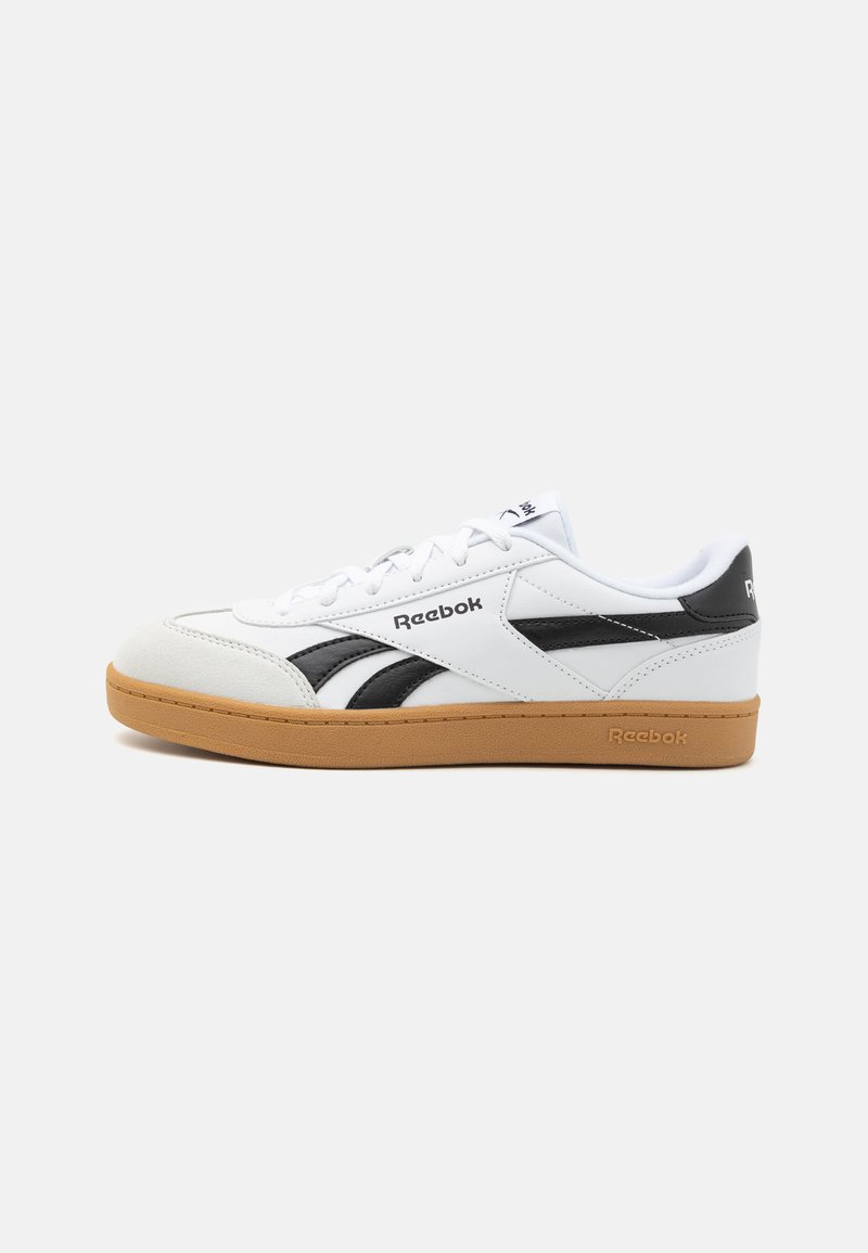 Baltie kedas ar melniem akcentiem, piedāvājot teksturētu gumijas zoli, aukliņu dizainu un Reebok logo sānos un mēlītē.