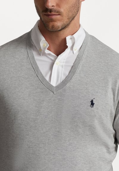 Gray V-neck sweater made of soft knit material with ribbed accents. Features a small navy logo on the left chest. Worn over a white collared shirt.