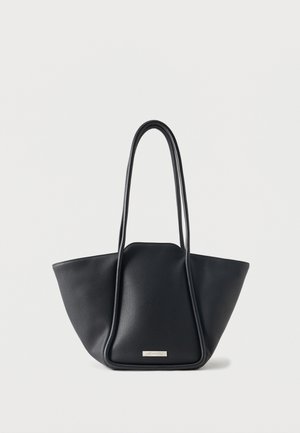 Sort læder-tote taske med struktureret design og lange hanke, sat mod en ensfarvet lys baggrund.