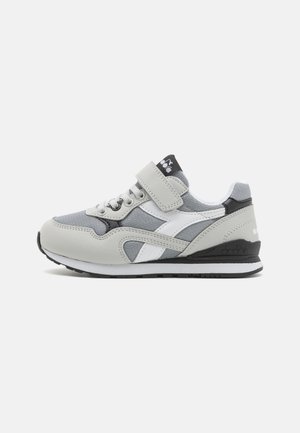 Scarpe da ginnastica grigie caratterizzate da una combinazione di materiali sintetici e tessili, collo imbottito, lacci e una fascia in Velcro. Accenti neri.