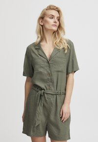 Olivenfarbener Kurzarm-Overall aus leichtem Stoff, mit einer Knopfleiste vorne, zwei Brusttaschen und einem gebundenen Taillengürtel.