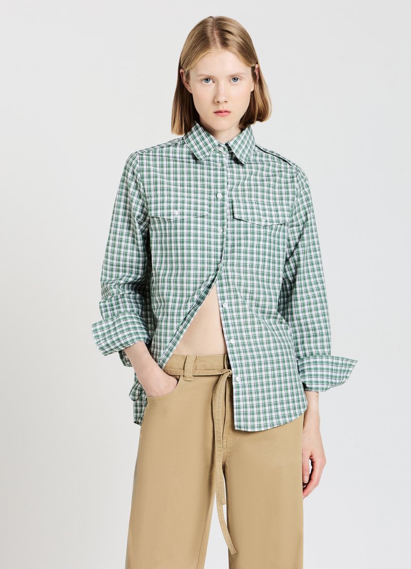 Green and white checkered shirt with a button-down collar, two chest pockets, and rolled-up sleeves, paired with tan pants.
