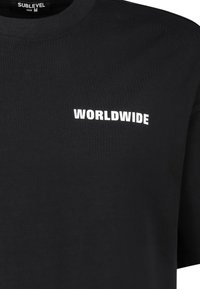 Black cotton T-shirt with a crew neck and short sleeves. Features the word "WORLDWIDE" in white text on the front. Size M.