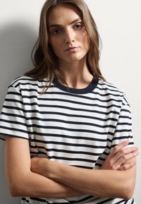 Gestreepte korte mouwen t-shirt met navy en witte horizontale strepen. Ronde kraag in navy, met een ontspannen pasvorm en een gladde katoenen textuur.
