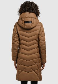 Hnědý péřový kabát s chevronovým prošíváním, kapucí a logem na zadní straně. Dlouhé rukávy a délka do poloviny stehna.