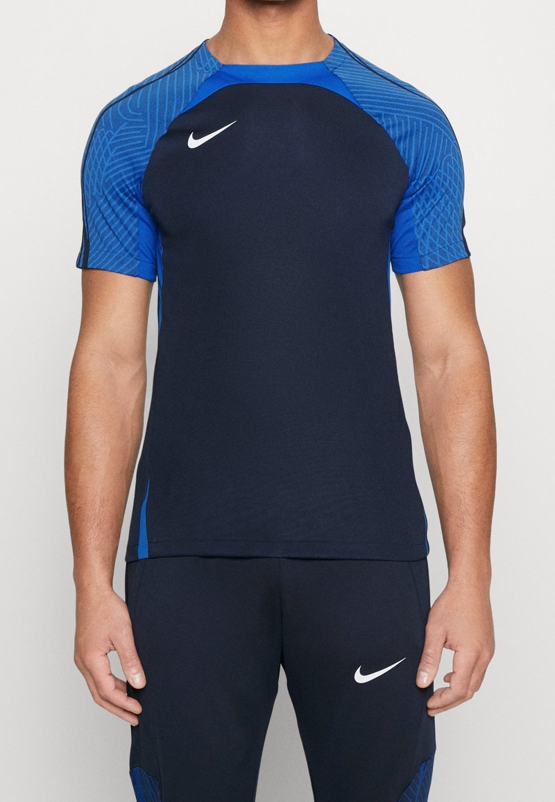 Marinblå sporttröja med mönstrade ärmar i blått. Tillverkad av andningsbart material, har rund halsringning och Nike-logotypen på bröstet.