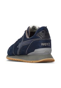 Sneaker scamosciato blu navy con accenti grigi, suola in gomma e tacco imbottito con il testo "W6YZ." Design con punta rotonda.