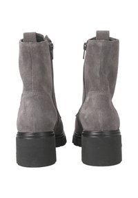 Bottines en daim gris avec un talon épais noir, dotées de zips latéraux et d'une texture lisse. Le design comprend des tirettes à l'arrière pour un enfilage facile.