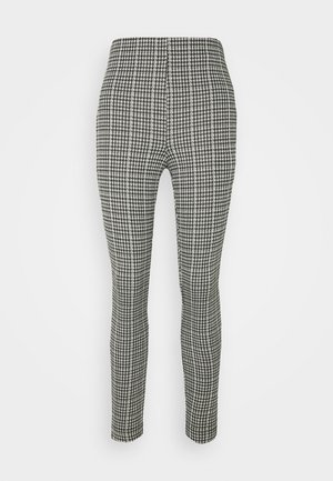Pantalons à motif pied-de-poule noir et blanc avec un design ajusté, jambes fuselées et texture de tissu lisse. Taille élastique, sans fermeture.