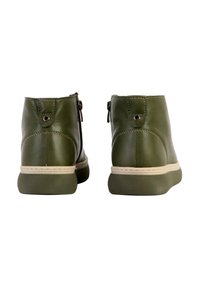 Green leather ankle boots with a smooth texture, side zippers, a light-colored sole, and decorative stitching along the edges.