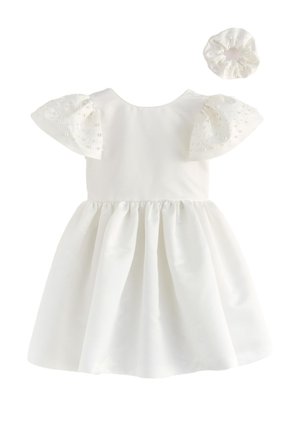 Witte babyjurk met pofmouwen versierd met parels, gecombineerd met een bijpassende parelversierde stoffen scrunchie.