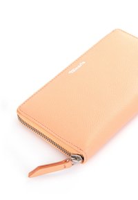 Zip-around wallet in light peach textured leather, with silver-tone hardware and a subtle logo on the exterior.