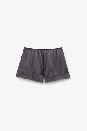 Shorts de satén gris oscuro con un acabado suave. Presentan un borde de encaje en el dobladillo, cintura elástica y un diseño de ajuste holgado.