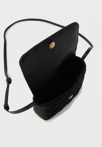 Μαύρη καπιτονέ τσάντα χειρός με χρυσό μαγνητικό κούμπωμα, δερμάτινο λουρί και απλή εσωτερική σχεδίαση. Υφή με πολλές θήκες.