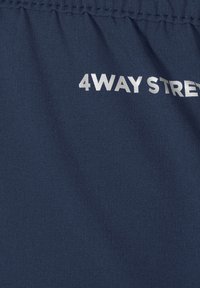 Navy fabric featuring the text "4WAY STREET" in silver lettering, with a smooth texture and elasticated waistband detail.