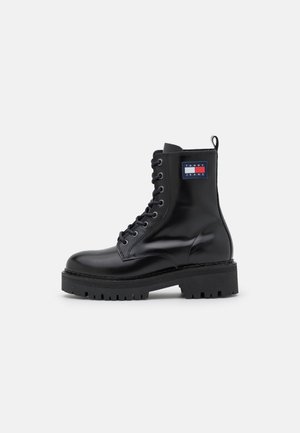 Botte de combat en cuir noir à lacets avec semelle épaisse et écusson du logo Tommy Jeans à la cheville.
