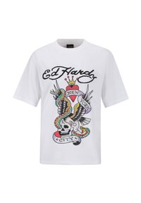 Vit kortärmad t-shirt med en färgglad tatueringsinspirerad grafik som föreställer ett skalle, en örn, ett hjärta och en orm, samt texten "Ed Hardy" och "New York City."