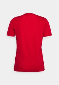 Camiseta roja de manga corta con cuello redondo y una textura de tela suave, con costuras limpias y sin patrones o acentos visibles.