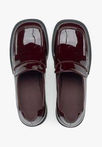 Bordeaux patentleren instappers met een ronde neus en een platte zwarte zool. Bevat een opvallende band over de bovenkant met subtiele stikseldetails.